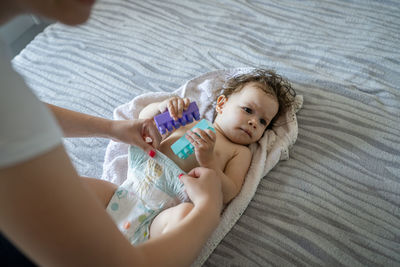 High angle view of cute baby girl lying on bed at home