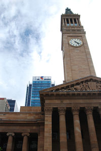 Low angle view of clock tower against cloudy sky