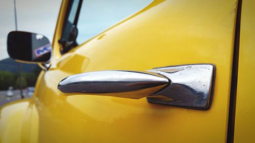 Close-up of yellow car on side-view mirror