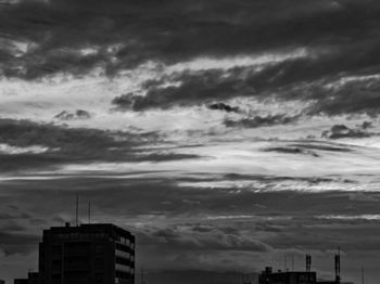 Low angle view of buildings against cloudy sky
