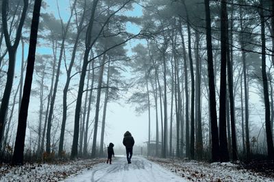 Rear view of women walking on snow covered landscape