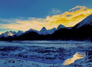 Scenic view of lake against mountains during sunset