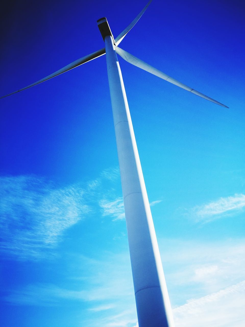 LOW ANGLE VIEW OF WINDMILLS AGAINST BLUE SKY