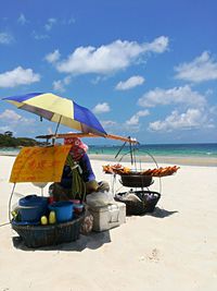 Lounge chairs on beach against sky