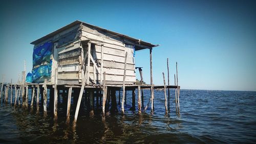 Built structure on beach against clear blue sky