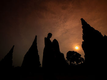 Silhouette people standing against sky during sunset