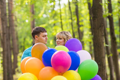 People with balloons in park