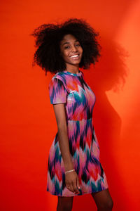 Portrait of a smiling young woman against red background