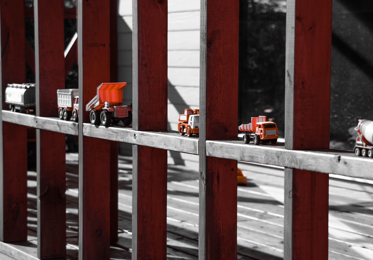 railing, fence, metal, animal themes, built structure, wood - material, architecture, safety, bird, building exterior, day, protection, outdoors, security, cage, wooden, one animal, in a row, focus on foreground, no people