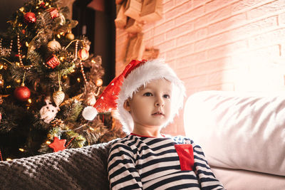 Boy in christmas tree at home