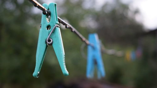 Close-up of clothespins hanging on rope