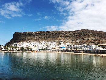 Buildings by sea against sky in town