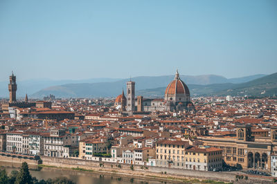 Aerial view of buildings in city against clear sky