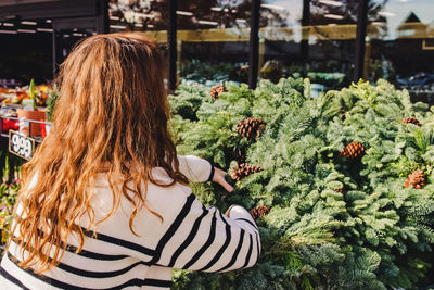 Rear view of woman standing by plants