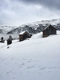 Houses on snow covered landscape against sky