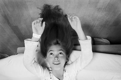 Upside down image of girl lying on bed at home