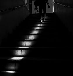 Low section of woman walking on staircase