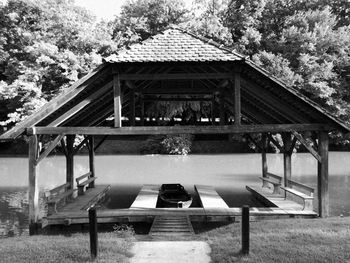 Gazebo in park by lake against sky