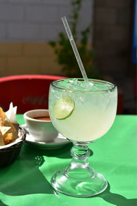 Large glass of lemonade with lime slice in glass served in mexican restaurant 