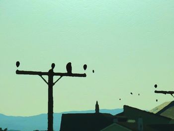 Low angle view of silhouette birds flying against clear sky
