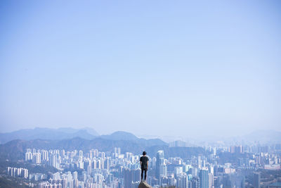 Rear view of woman standing against clear sky