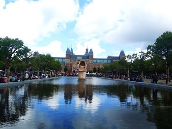 People on water in city against sky