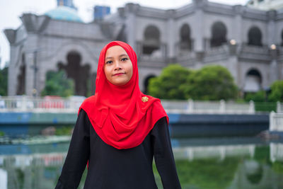 Portrait of woman standing against red water