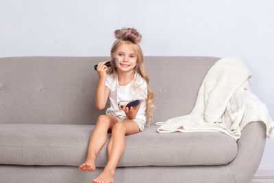 Portrait of smiling young woman sitting on sofa