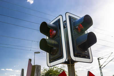 Traffic lights before the railway crossing with a red light to warn of approaching trains.