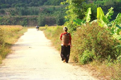 Rear view of woman walking on footpath