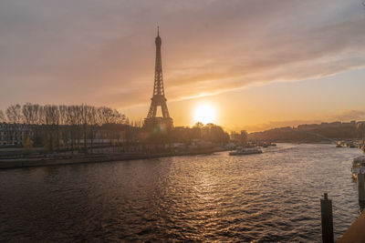 Tower in city against sky during sunset