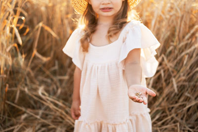 Portrait of young woman standing on field