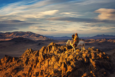 Rock formations on landscape against sky during sunset