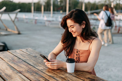 Full length of a young woman using mobile phone