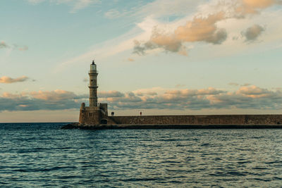 Lighthouse in sea against sky