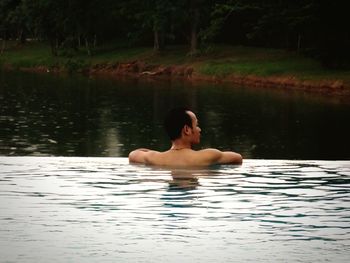 Portrait of shirtless man swimming in pool