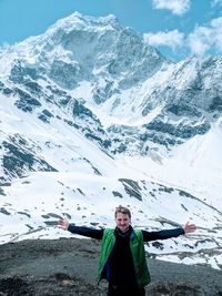 Portrait of man standing on snow covered mountain