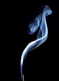 Close-up of burning incense against black background