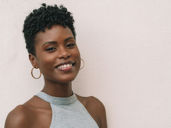 Portrait of smiling mid adult woman against wall