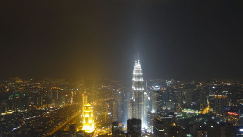 Illuminated city against sky at night