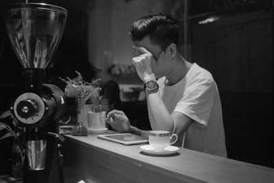 Portrait of man with drink on table in restaurant