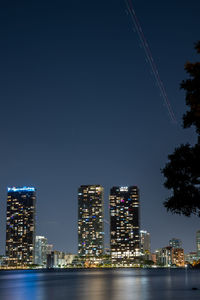 Illuminated buildings against sky at night