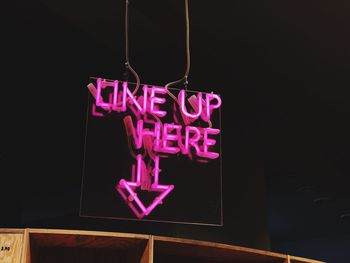 Close-up of heart shape hanging on pink store