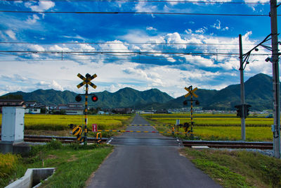 Road leading towards mountains against sky