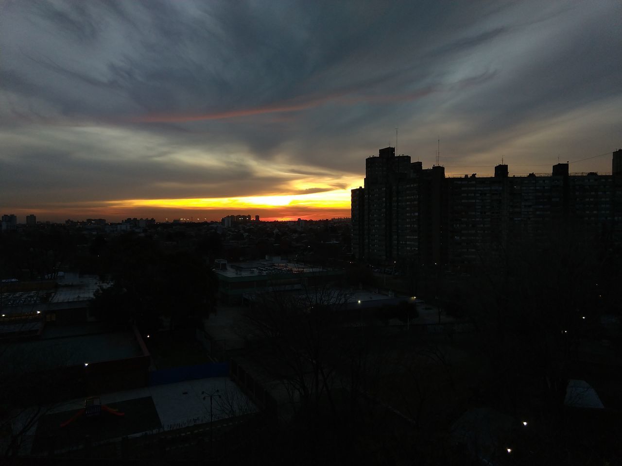 HIGH ANGLE VIEW OF SILHOUETTE BUILDINGS AT SUNSET