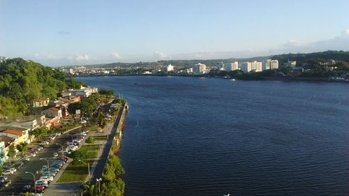 High angle view of city by sea against sky