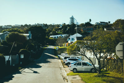 Road amidst trees against sky in city