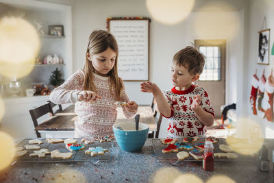 Boy and girl siblings decorating christmas cookies