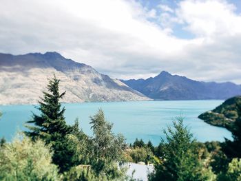 Scenic view of lake and mountains against cloudy sky