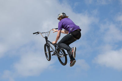 Low angle view of woman jumping on skateboard